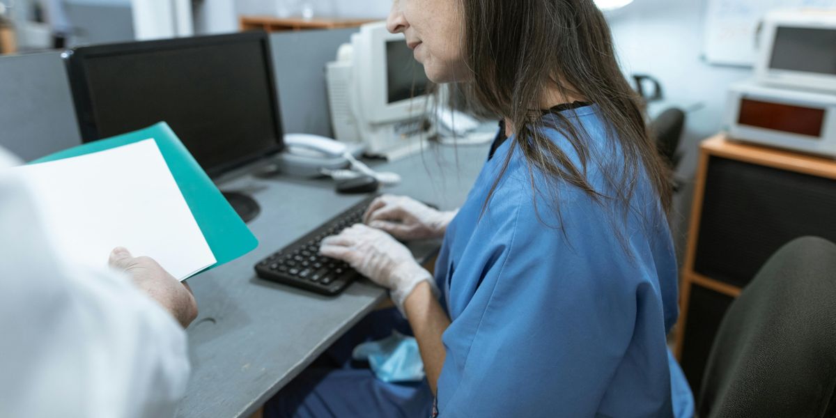 Nurse typing resume on laptop