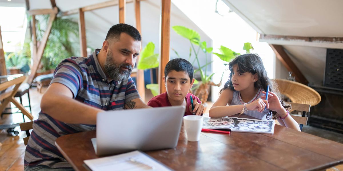 Father working from home office with child in background