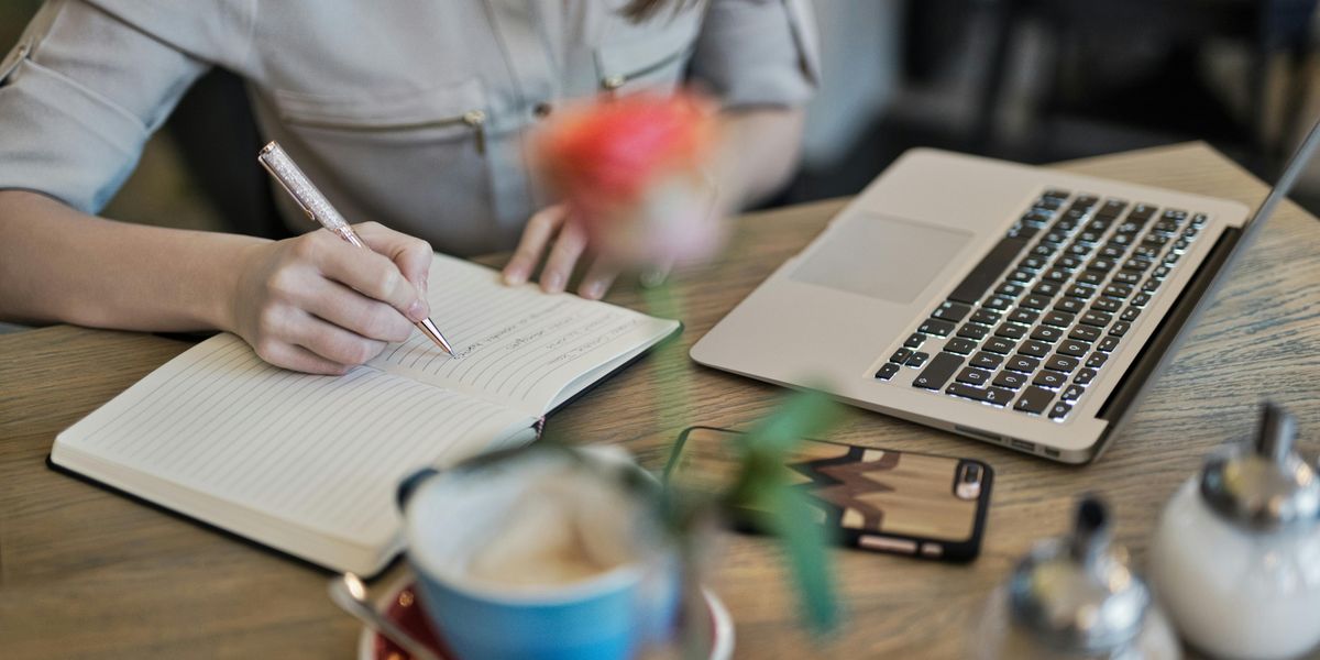Father writing articles on laptop in home kitchen