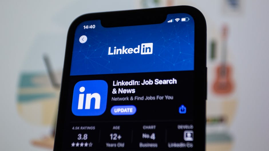 Young professional updating LinkedIn profile on laptop